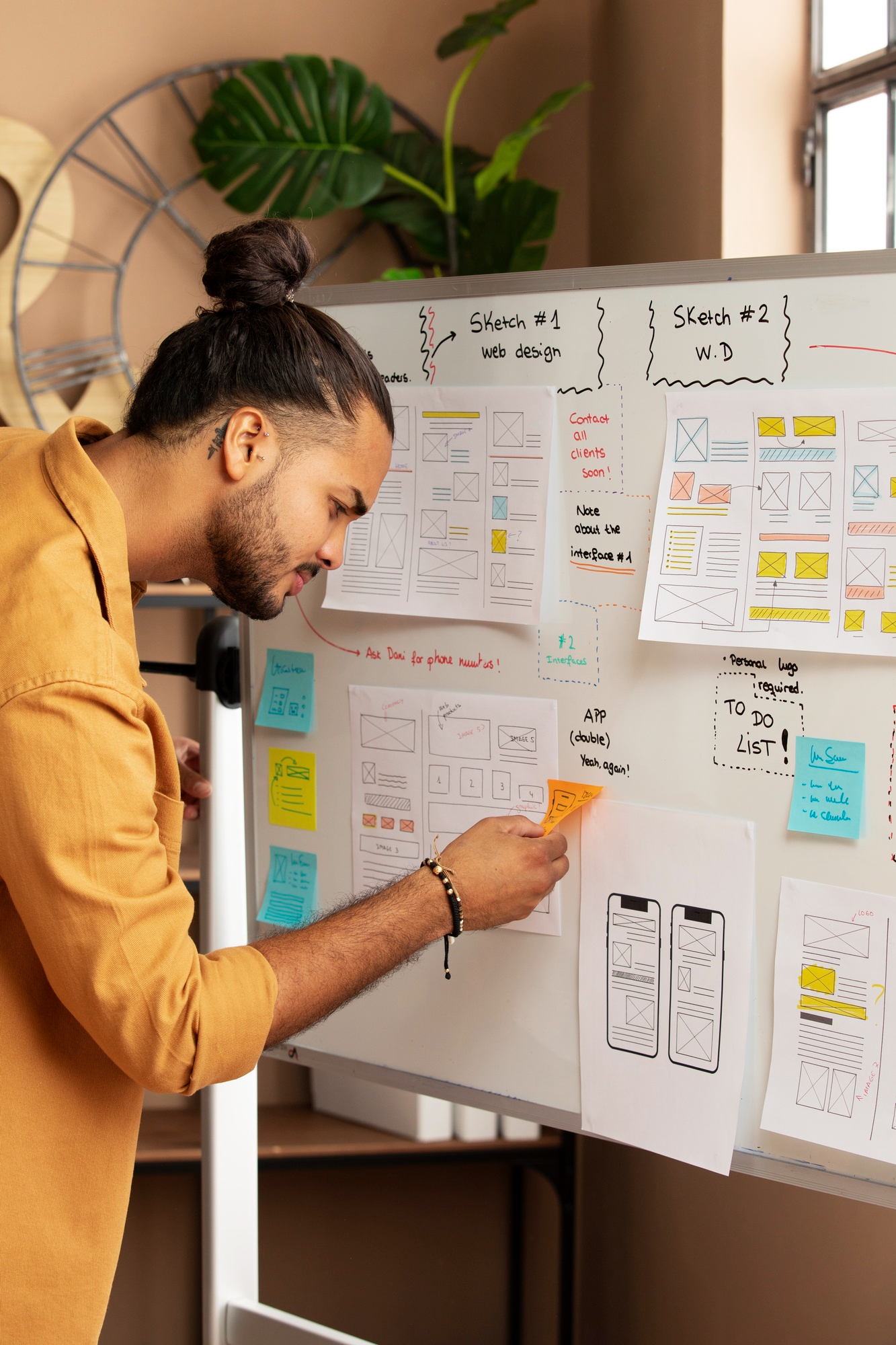 Designer pinning notes on a wireframe wall